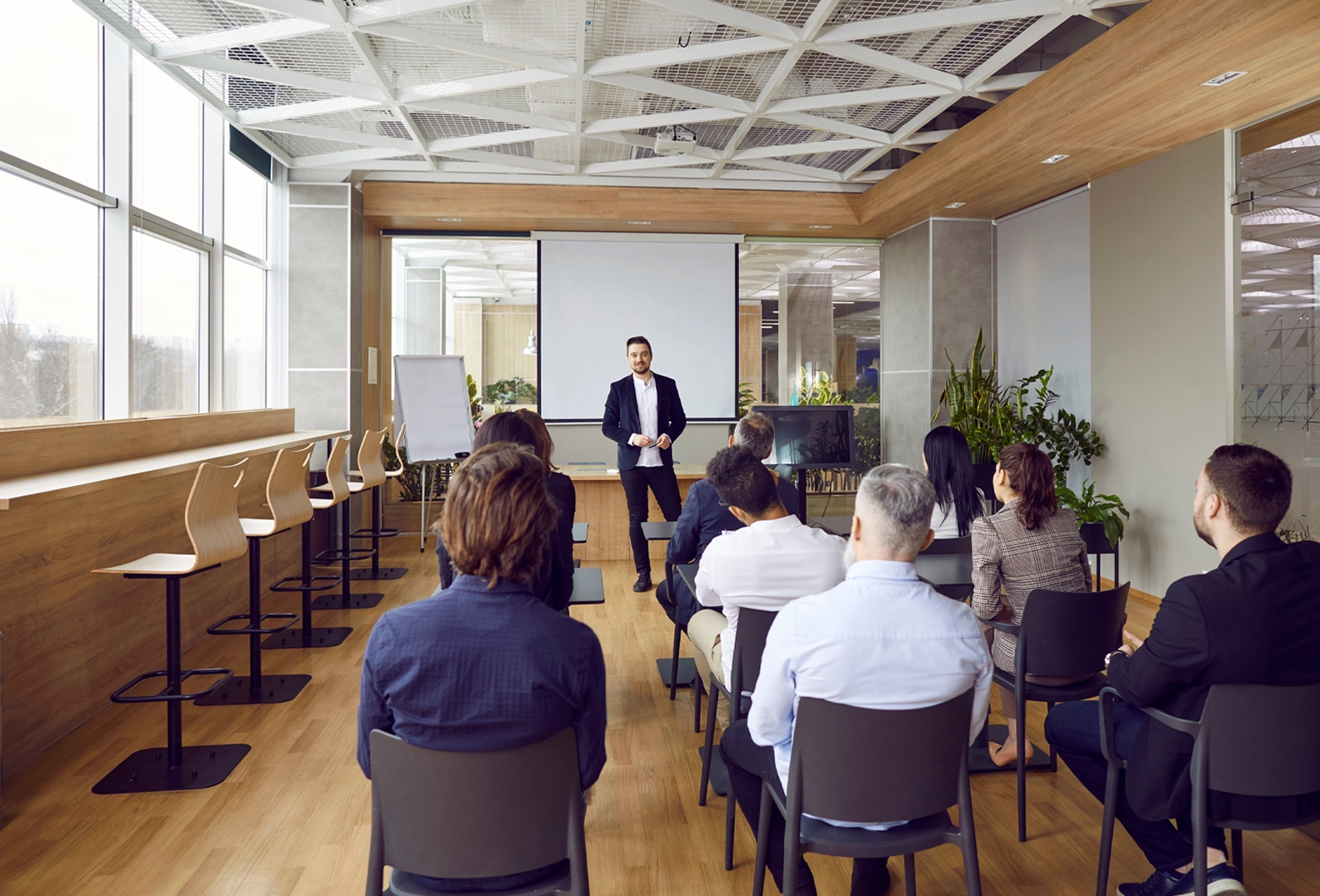 A man speaking in a small room full of people