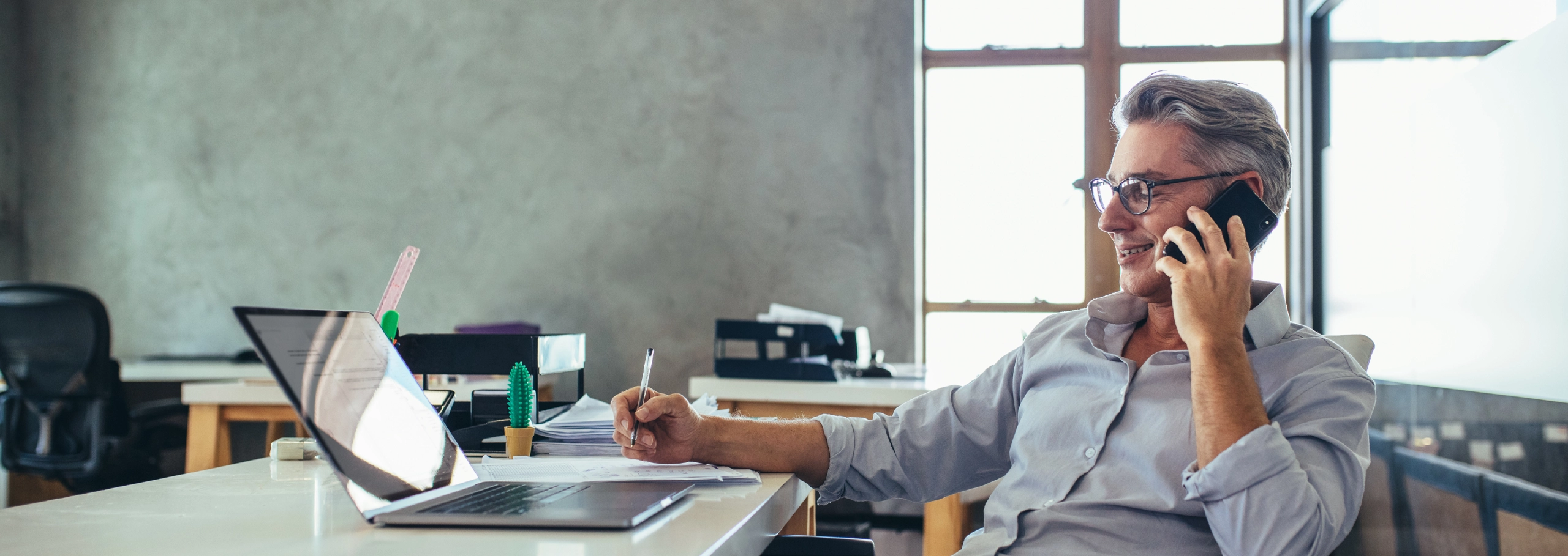 Man sitting at a desk talking on the phone