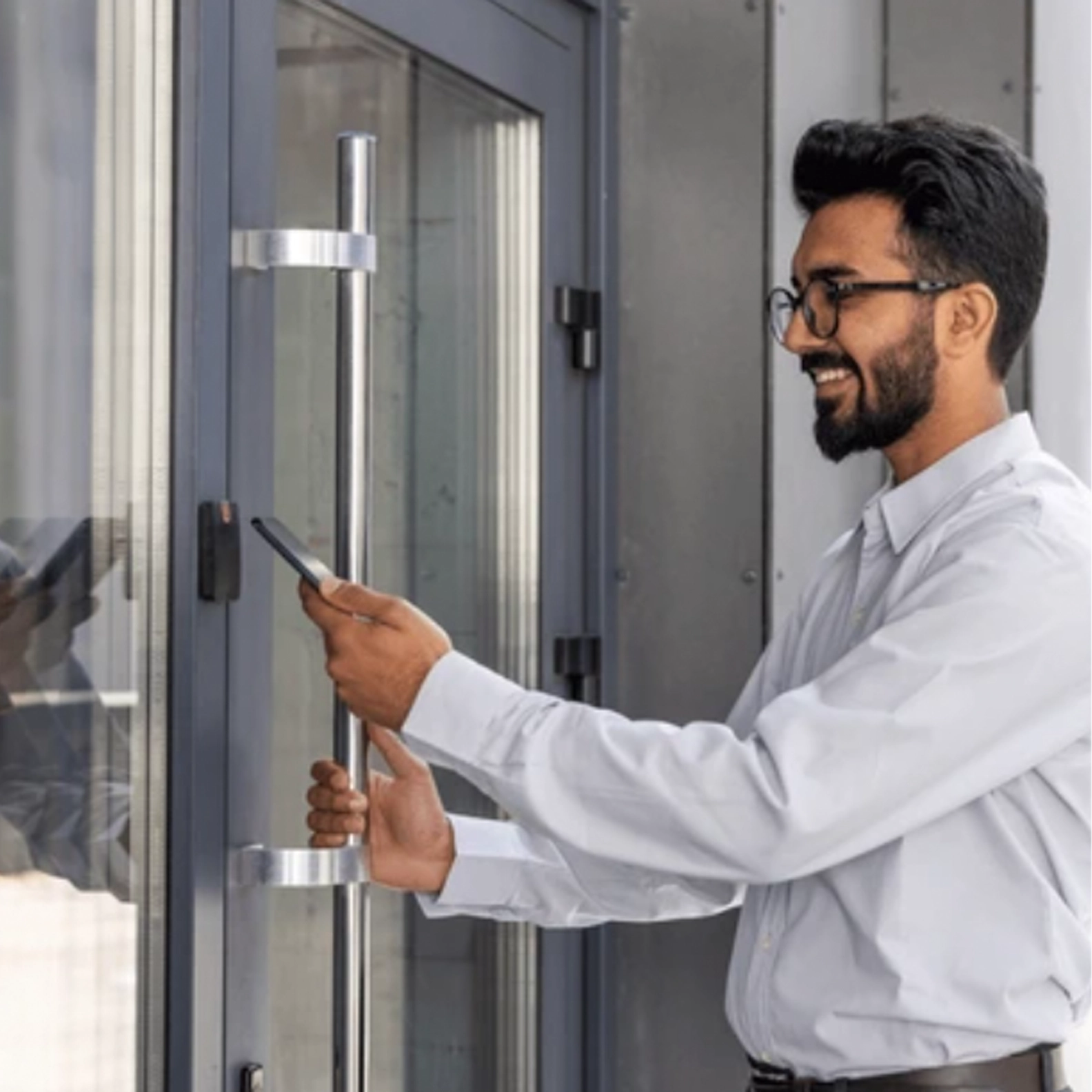A man using his phone to unlock a residential lobby door
