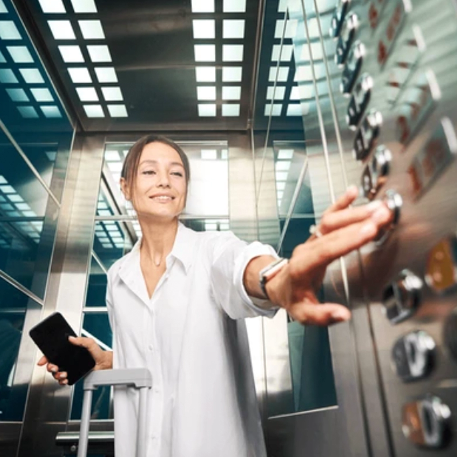 A woman pushing a button in an elevator