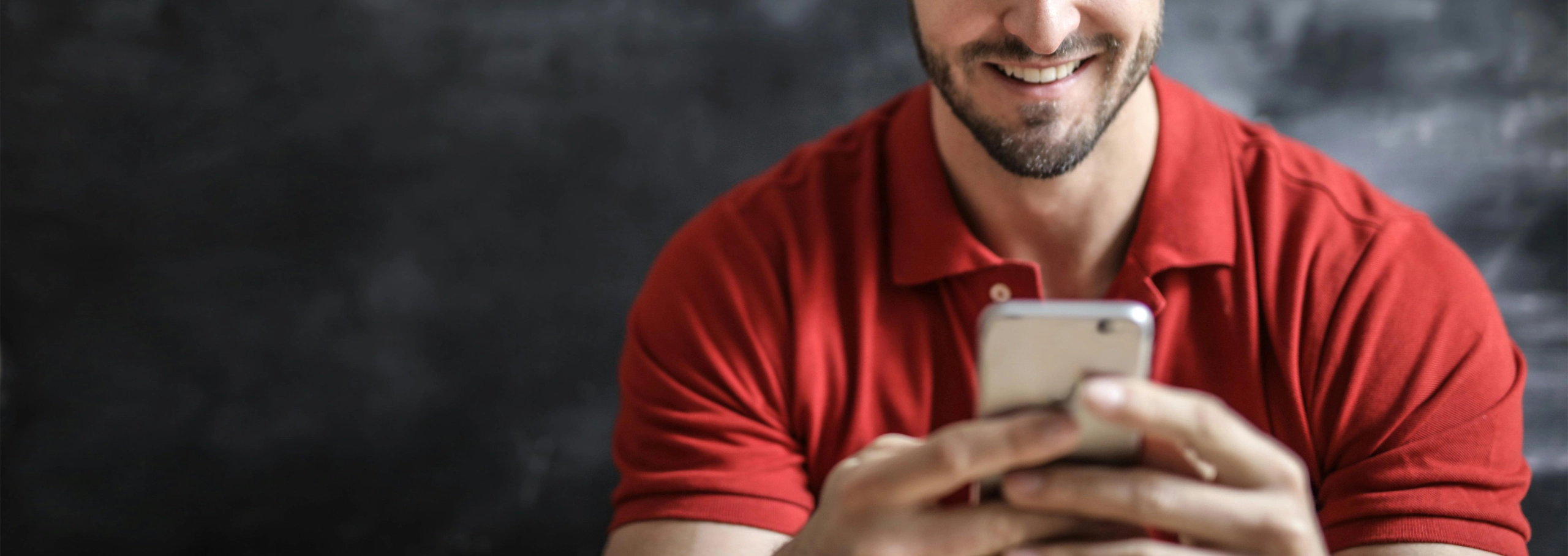 Man in a red shirt on his phone