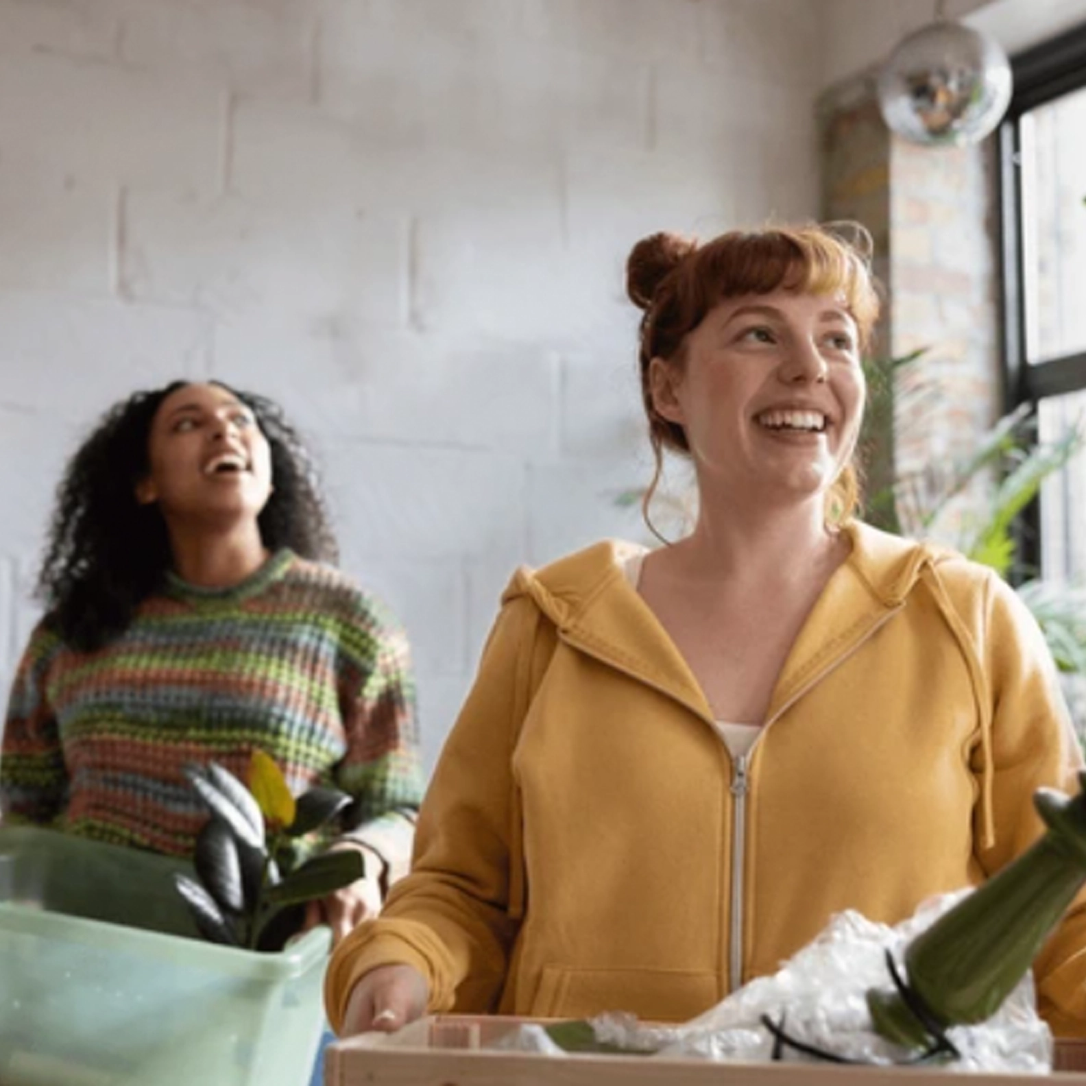 Two women carrying boxes of personal belongings