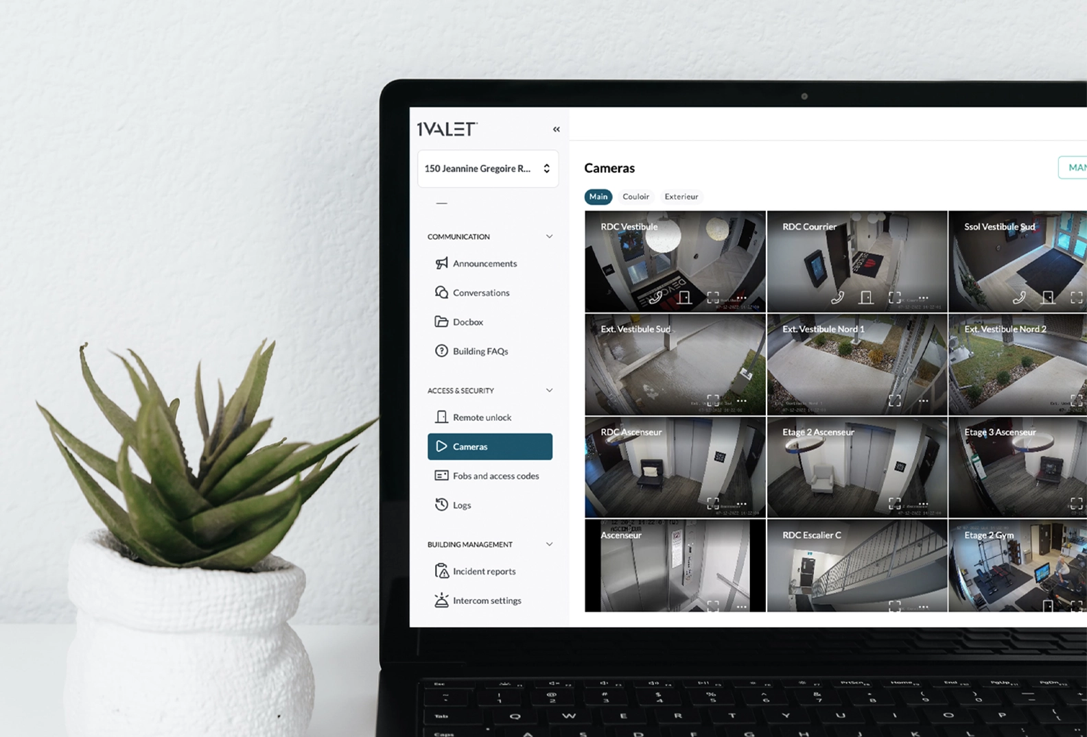 1VALET's CCTV feature mocked up on a laptop beside a plant