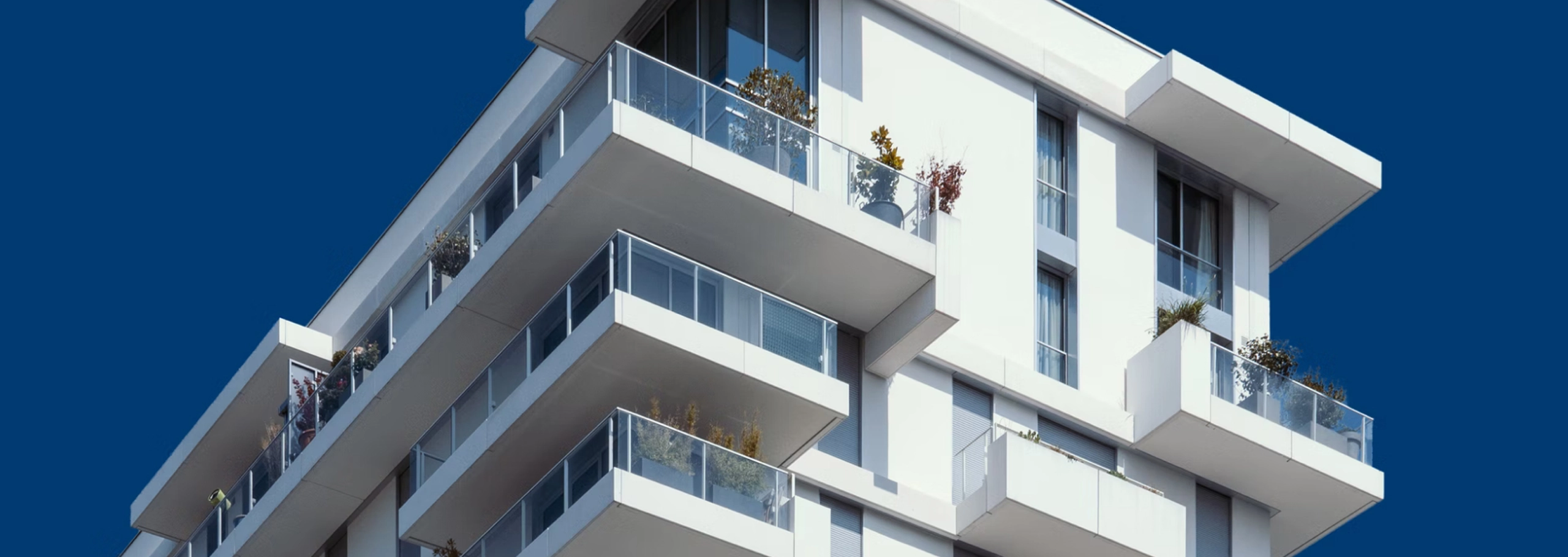 Modern white stucco building with blue sky in the background
