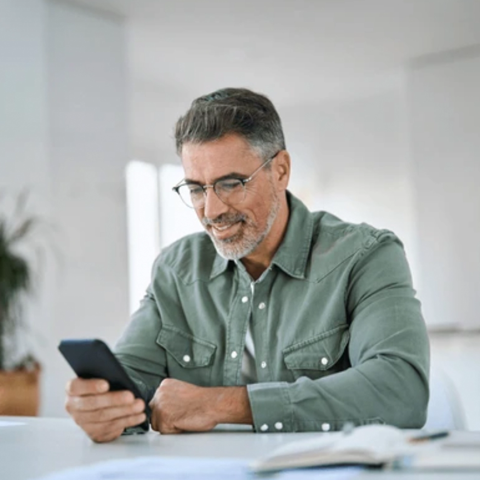 A man using his smartphone at a desk