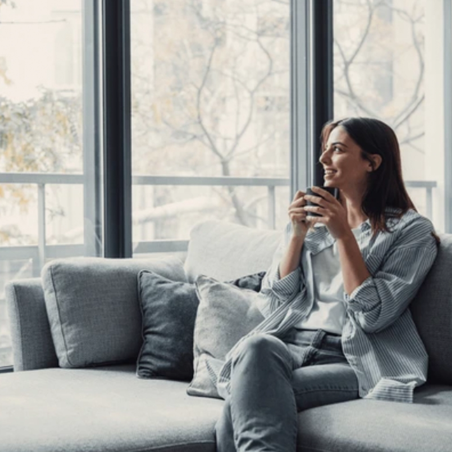 Woman sitting on the sofa drinking coffee