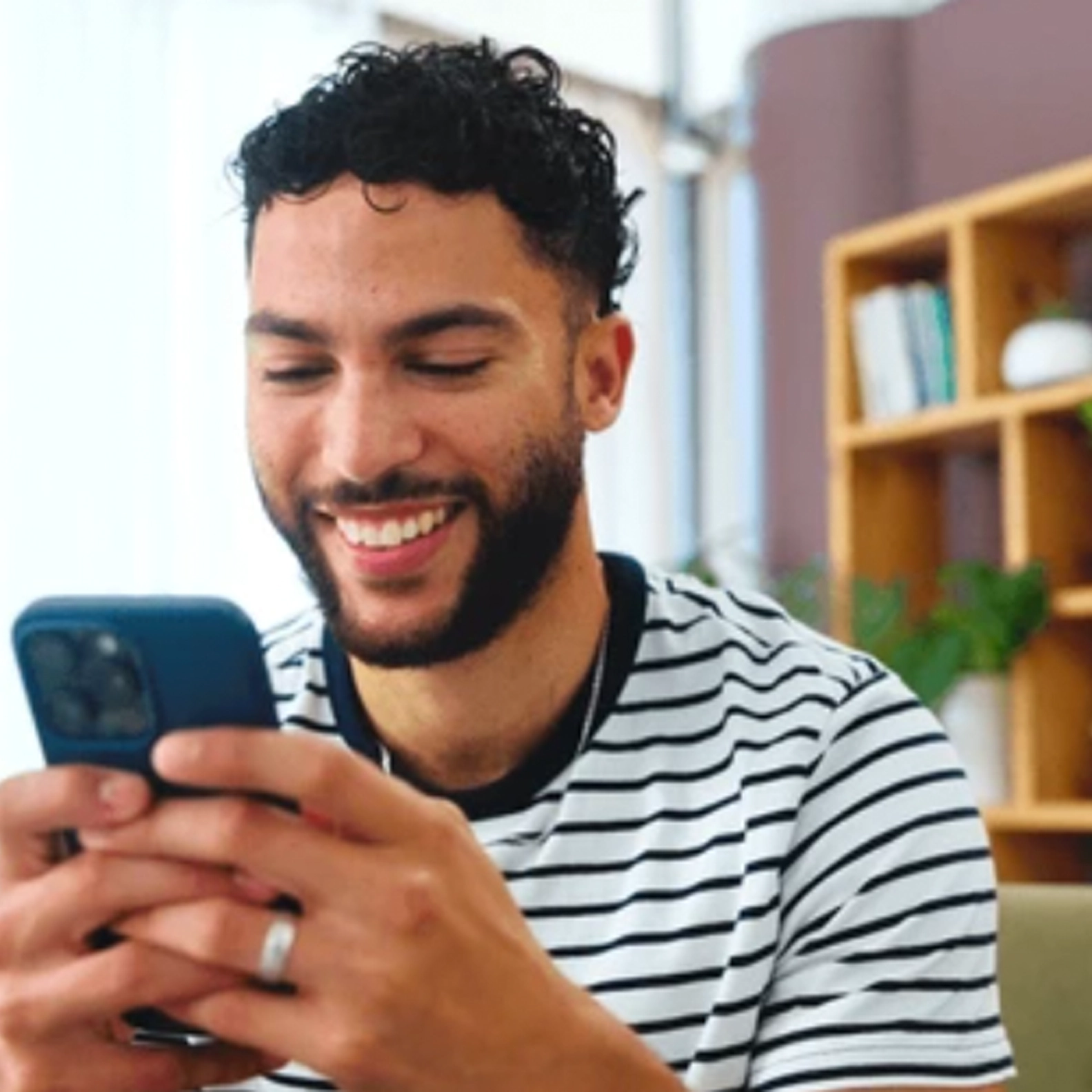 Smiling man using his smartphone to message